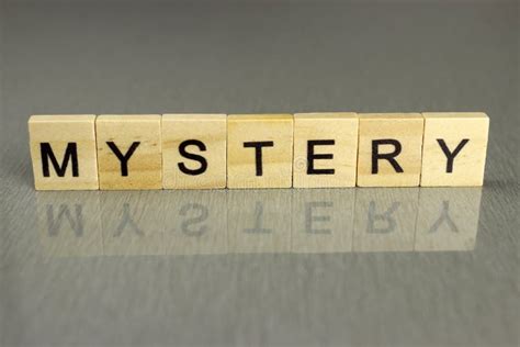 The Word Mystery Is Made Up Of Square Wooden Letters On A Gray