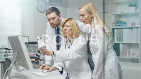 Group Of Three Medical Specialists Solving Problems At The Desktop