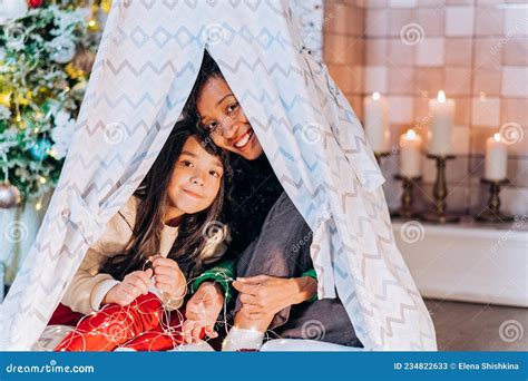 Daughter And Black Mother Play Hiding Under Blanket Hut Stock Image