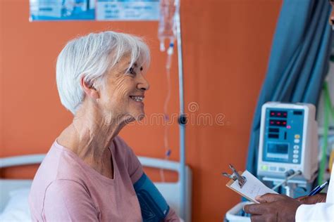 Smiling Senior Caucasian Female Patient Having Her Blood Pressure Taken