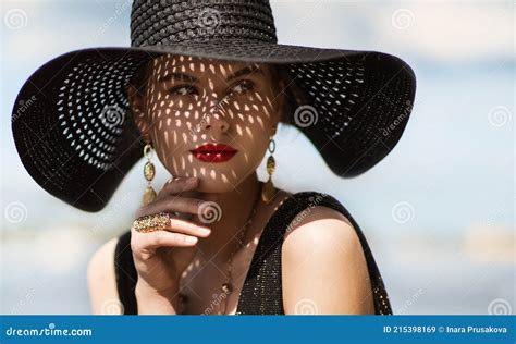 woman in hat portrait fashion luxury model in black summer hat with make up and golden jewelry