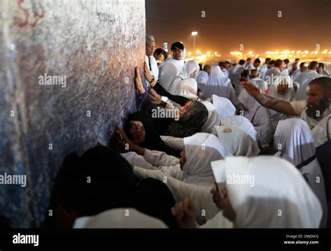 Muslim Pilgrims Pray In Front Of A Pillar Where Islams Prophet