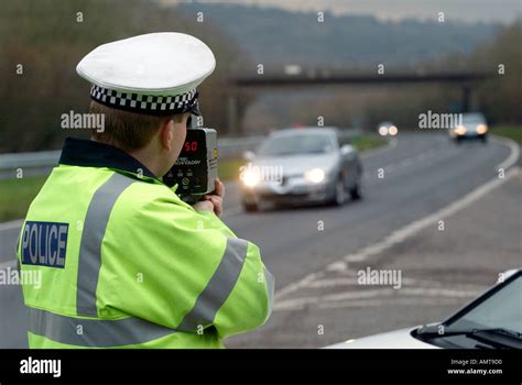 British Traffic Police Officer Monitors The Speed Of Road Traffic Using