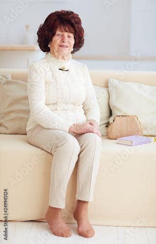 Portrait Of Beautiful Mature Woman 80 Years Old Sitting On Sofa At