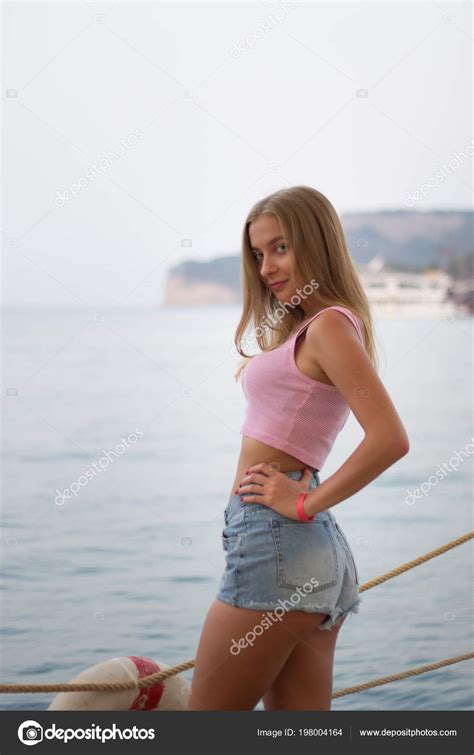 Portrait Of Young Sexy Blonde Woman In Short Shorts By The