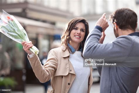 Woman Hitting A Man With A Bouquet Of Flowers High Res Stock Photo