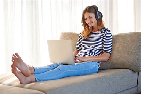 Royalty Free Woman With Bare Feet On Sofa Listening To Mp3 Player Pictures Images And Stock