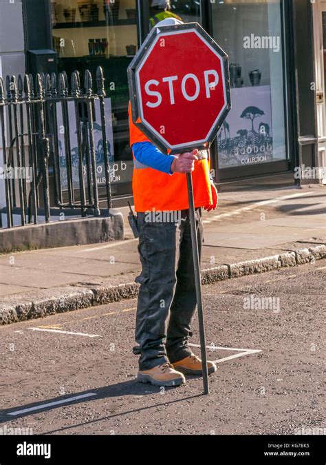Road Worker Standing In Road Holding Stop Sign London Stock Photo Alamy