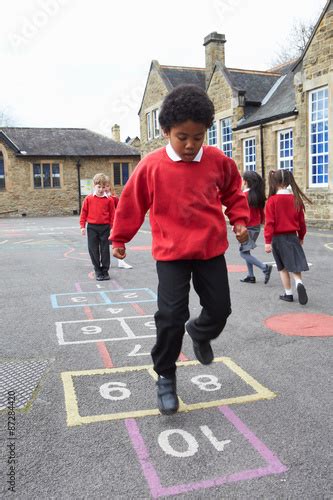 Group Of Children Playing Hopscotch In School Playground Buy This