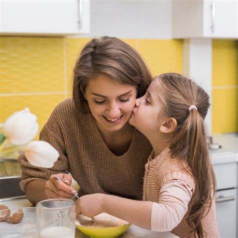 Jolie Fille Embrasse Mère En Cuisinant Dans La Cuisine Photo Gratuite