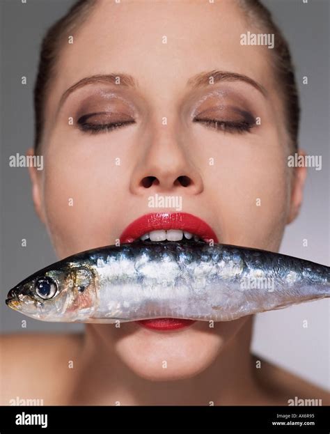 Woman With Fish In Her Mouth Stock Photo Alamy
