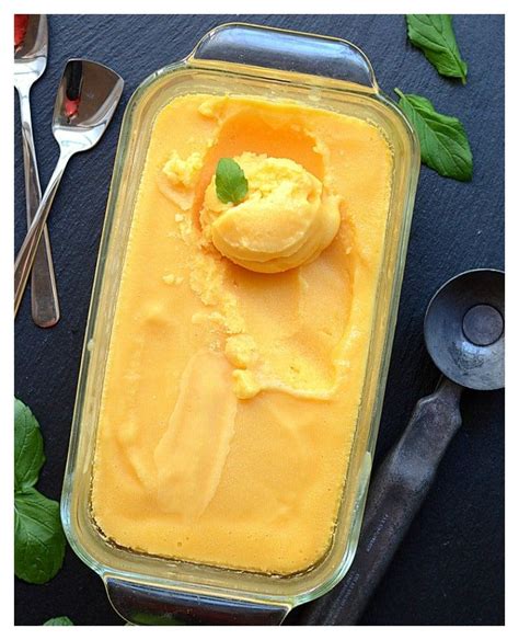 An Ice Cream Dish On A Table With Spoons And Mint Leaves Next To It