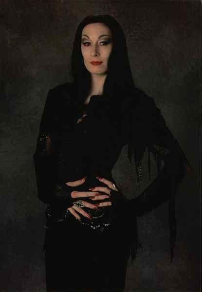 A Woman With Long Black Hair Is Posing For A Photo In Front Of A Dark
