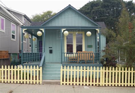 Exterior Green American Craftsman Styled Bungalow With Yellow Fence