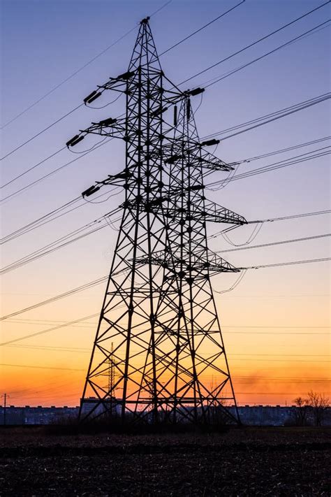 High Voltage Power Line In A Field At Sunset Stock Photo Image Of