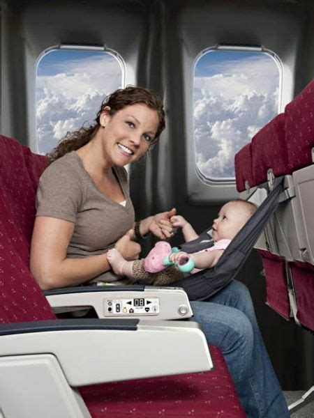 A Woman Sitting On An Airplane With A Baby In Her Lap And The Seat Is Empty