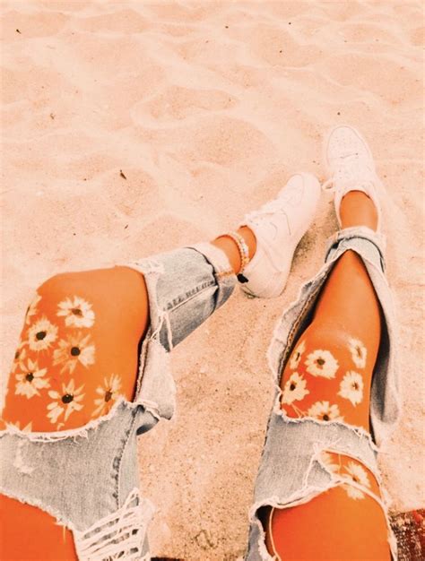 The Legs And Ankles Of A Woman In Ripped Jeans With Flowers Painted On