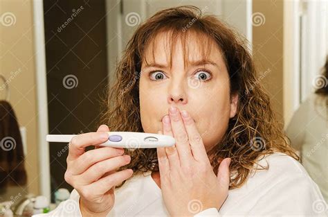 Urprised Middle Aged Woman Holding A Positive Pregnancy Test Stock