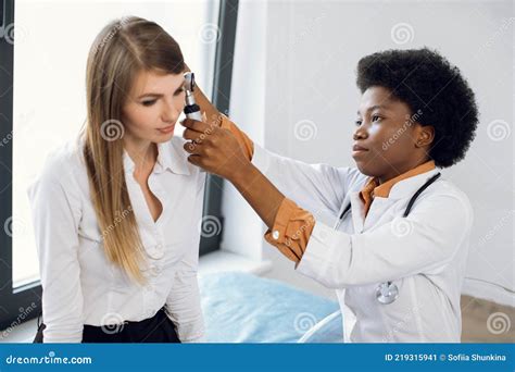 Ent Doctor And Patient In Modern Hospital Female Confident African American Doctor Doing Ear