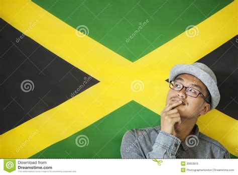 Jamaican Flag With Stack Of Money Coins With Grass Royalty Free Stock Photography