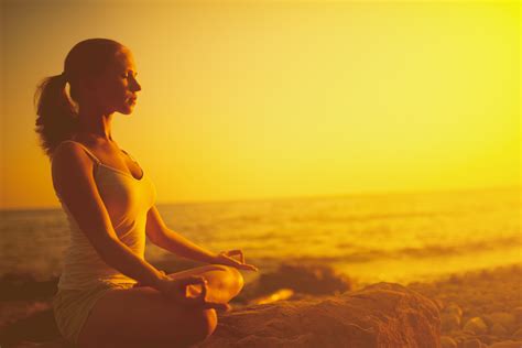 Woman Meditating In Lotus Pose On The Beach At Sunset Dr Robert Brody