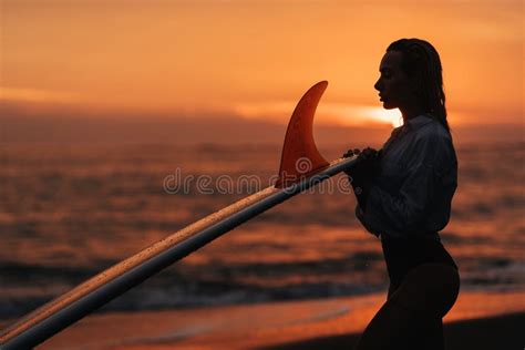 Woman On Tropical Beach Holding Surfboard At Sunset Stock Photo Image