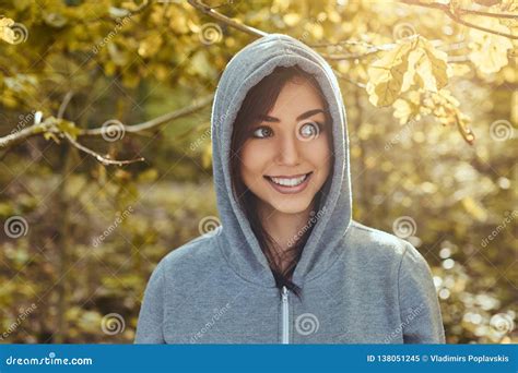 A Smiling Beautiful Girl Wearing A Gray Hoodie In The Autumn Park Stock