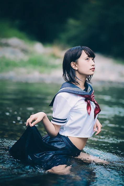 a woman sitting in the water wearing a sailor outfit