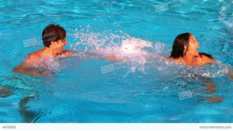 Couple Splashing And Having Fun In Swimming Pool Stock Video Footage