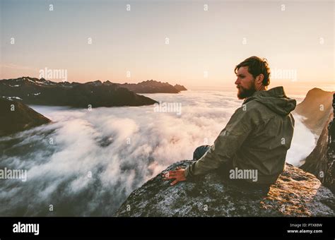 Traveler Man Sitting Alone On The Edge Cliff Mountains Above Clouds