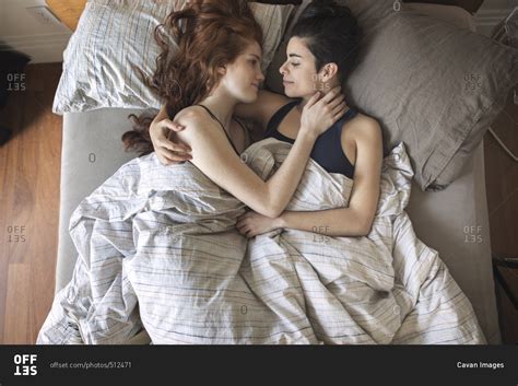 High Angle View Of Romantic Lesbian Couple Looking At Each Other While Lying On Bed Stock Photo