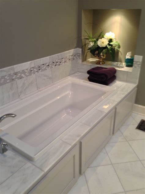 Adhesive surround kits can be installed over just about any flat wall surface in good condition, including tile or drywall. Drop in jacuzzi bath tub with tile backsplash and cabinet ...