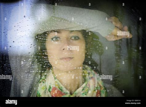 Young Woman Looking Through The Window On A Rainy Stock Photo Alamy