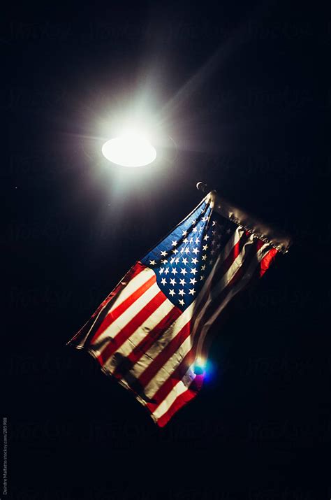 American Flag Lit By A Streetlight At Night By Stocksy Contributor