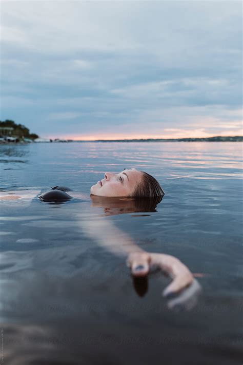 Young Woman Floating In Calm Water At Sunset By Carey Shaw Float Relax