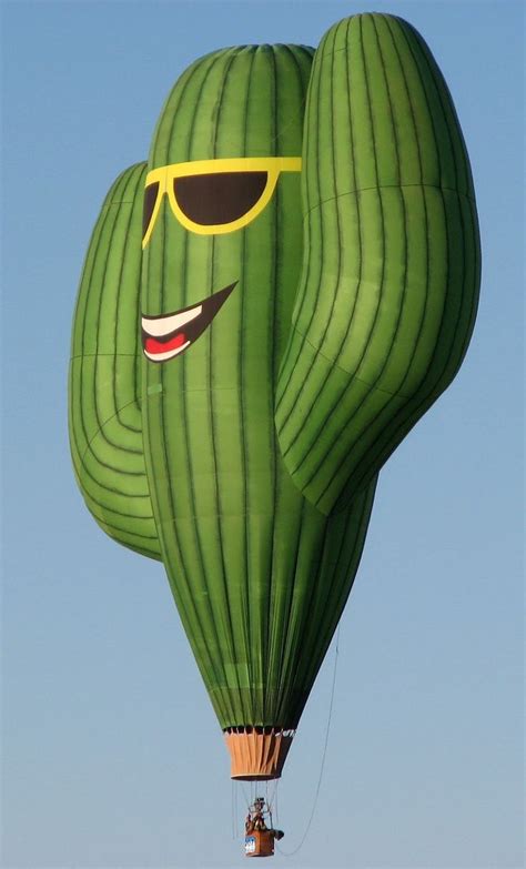 A Large Green Hot Air Balloon With Sunglasses On Its Face And Smiling Eyes