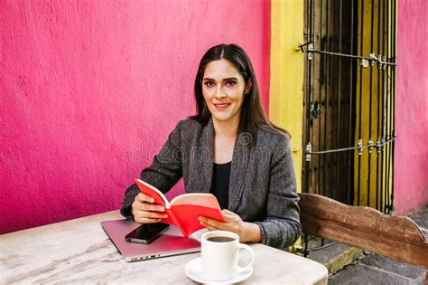 Mexican Woman Reading A Book In A Coffee Shop Terrace In A Colonial City Of Latin America Stock