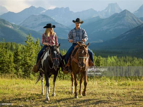 Cowboy And Cowgirl Ride Horse Thru Mountain Meadow Stock Foto Getty