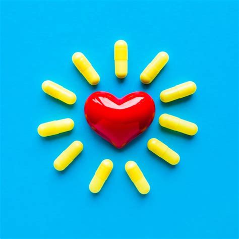 Premium Photo Yellow Pills Around A Red Heart Fell From A Bottle On A