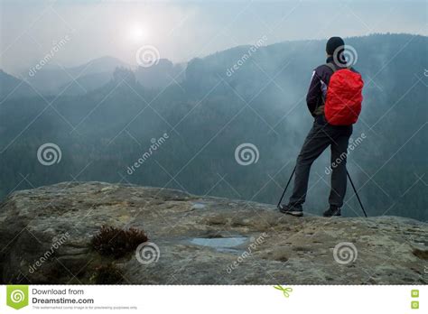 Hiker With Red Backpack On Sharp Sandstone Rock In Rock Empires Park And Watching Over The Misty