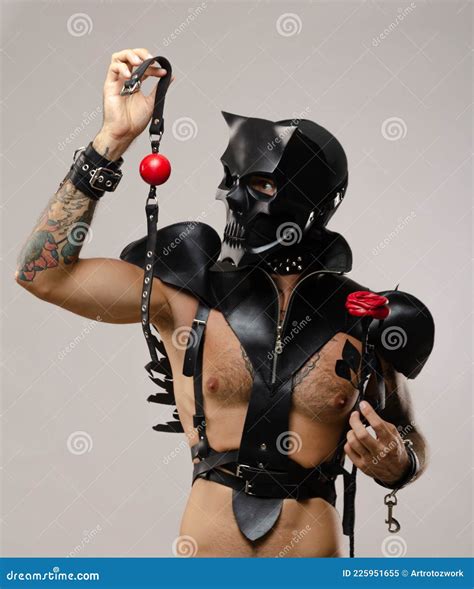 A Man In A Bdsm Mask Of A Skull Demon With A Gag Dressed In A Leather