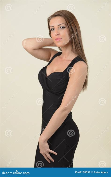 brunett med långt hår i svart klänning fotografering för bildbyråer bild av skönhet afton