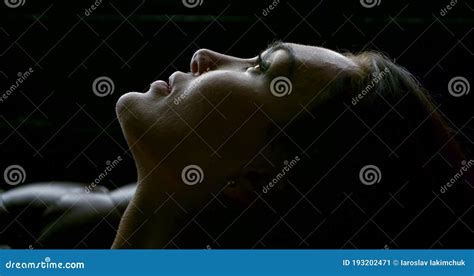 close up of a face in profile of a woman who lies resting with her head thrown back stock image