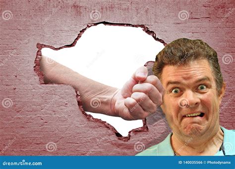 Surprise Assault Punch From Hole In Brick Wall Attack Stock Photo