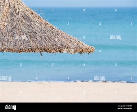 Summer Landscape With Straw Umbrellas On The Beach In Mangalia Or Mamaia Beach At The Black Sea