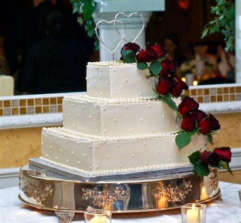 The terms 'cake tin' and 'cake pan' are commonly used to mean the same thing and preferred usage differs from country to country. Three tier square ivory wedding cake with red roses and ...