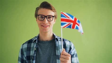 Portrait Of Proud Englishman Holding Flag Of England Smiling Looking At