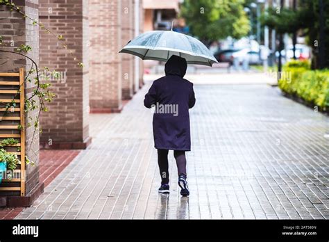 A Lonely Person Walks A Rainy Day Covering Himself With An Umbrella