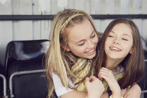 Portrait Of Two Smiling Girls Hugging In Stadium Stand — 10 To 11 Years Friendship Stock
