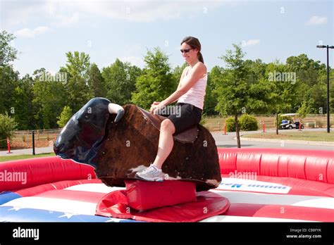 Woman Riding A Mechanical Bull At A Festival Stock Photo Alamy